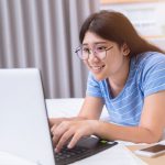 Teen Doing Homework on Computer at Home