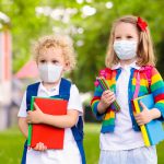 Two children wearing masks ready for school