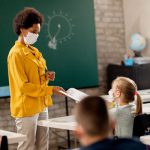 teacher and students wearing protective face masks in the classroom